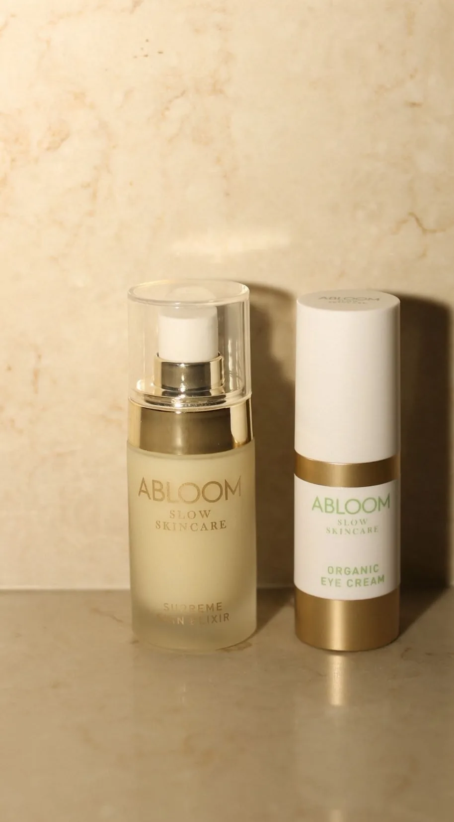 Abloom Supreme Skin Elixir en Organic Eye Cream op een marmeren plank