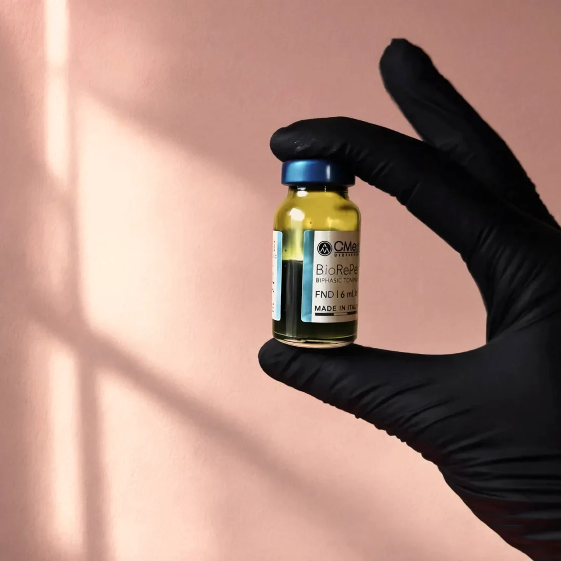 Flacon BioRePeel tussen vingers in een zwarte handschoen